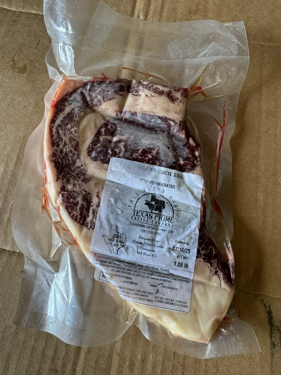 A vacuum-sealed Fullblood Wagyu ribeye showing dense marbling, labeled with the ranch's own private label